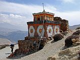 Mustang 02 09 Chorten On Shyangmochen La The trail from Shyangmochen climbs quickly to the Shyangmochen La (3850m) on the way to Geiling in Upper Mustang. With a cold wind blowing, we sat in the shadow of the beautiful colourful chorten at the top of the Shyangmochen La (3850m), with a stunning view of the surrounding peaks in sunshine.
